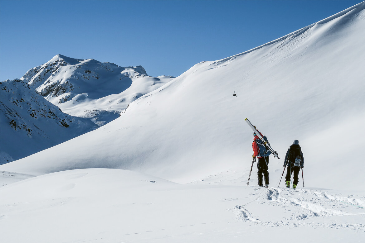 Ein bis zwei Mal pro Woche auf Tour. Lawinenforscher Bastian Bergfeld (mit der roten Jacke) wirft den Beschleunigungssensor vor sich in den Schnee, um zu messen, wie schnell sich Brüche in den Schichten fortpflanzen (oben). | Bild oben: Alec van Herwijnen, SLF.